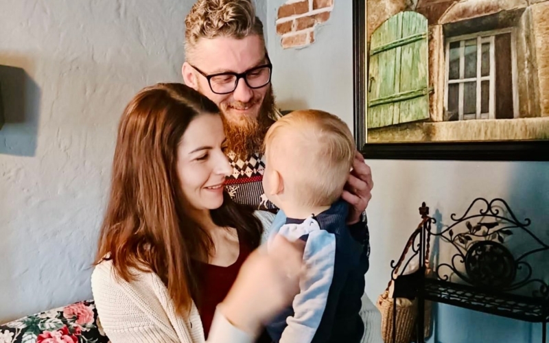 Mama i tata przytulają małego chłopca podczas pierwszego spotkania adopcyjnego
